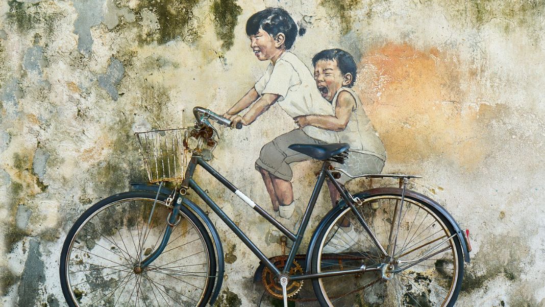 Niños en bicicleta, representando Infancia es destino. Diseño realizado a partir de la fotografía de Engin_Akyurt (extraída de Pixabay, CC0)